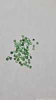 Group of round green tsavorite garnet stones on white background