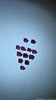 Cluster of square-cut deep red rubies on light background