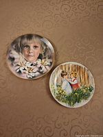 Front view of both Wedgwood collector plates showing artwork and gilt rims