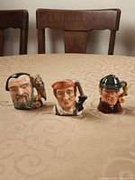 Front view of the three Royal Doulton miniature character jugs
