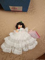 Scarlett Madame Alexander doll in white lace dress with hang tag, partial view of original box