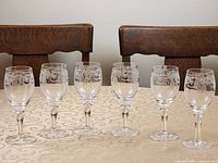 Front view of six etched crystal wine glasses on table