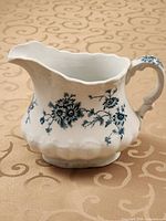 Left front view showing floral transfer design, rim shape and handle