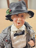 Close-up of doll’s face, hat, jacket, microphone