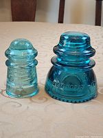 Front view of both insulators showing size difference, colors, and embossing