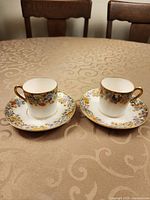 Two demitasse cups on matching saucers