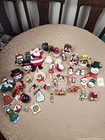 Single image showing entire assortment of Christmas ornaments spread on round table