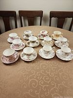 Twelve teacup and saucer sets on table