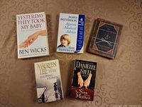 Five paperback books laid out showing front covers