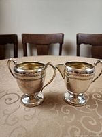 Front view of creamer and sugar bowl on tabletop
