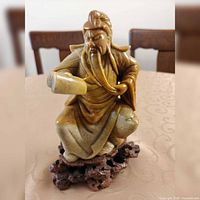 Full view of soapstone sage figurine on carved stand