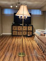 Full view of gold-tone floor lamp, shade, base and cord visible