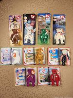 Nine Ty International Bears in sealed blister cards and clamshell cases laid out on table