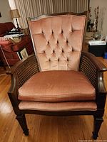 Front view of cane-back pink upholstered armchair