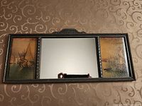 Full view of tri-panel mirror showing central mirror and two side prints