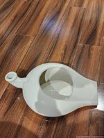 top view of white ceramic bedpan showing spout, handle opening and interior