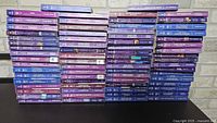 Six vertical stacks of purple/blue-spine Harlequin paperbacks on table
