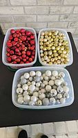 Three tubs of red, gold and silver ornaments