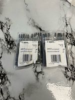 Two sealed packs of Bosch power bits on countertop