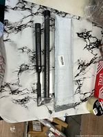 Two handle sections, bubble-wrapped sleeve, blade end visible