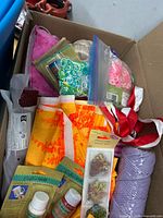 Overview of box showing yarn, fabric, loom bands, twine, paints, ribbons