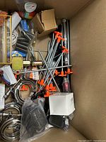 Top view of box showing clamps, threaded rods, springs, pipe fittings