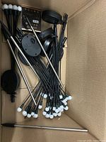 Top view of box showing numerous black stakes with white tips and base pieces