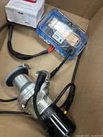 Wide view of all three items inside cardboard box: palm router, Unibraze welding wire box, DROK module