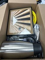 Box showing Umbra frame, stainless carafe, yellow rope and utensil