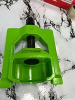 Front angled view of green OEMTOOLS U-joint puller showing frame, forcing screw and model number 24538