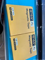 Two unopened yellow boxes labeled 15'×0.5" Magnetic Tape