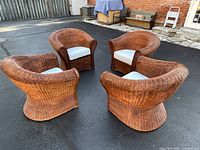 All four wicker tub chairs arranged outdoors showing overall condition and form