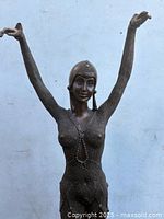 Front view of bronze dancer statue with raised arms