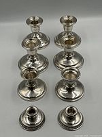 Eight sterling weighted candlestick holders in two rows