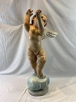 Front view of carved wood cherub standing on cloud base
