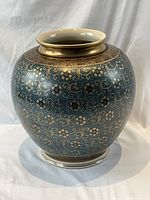 Full view of vase front showing blue ground, gold floral pattern, gilt neck
