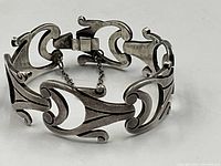Bracelet closed showing decorative scroll links and safety chain