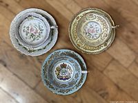 Three teacup and saucer sets, tops showing patterns