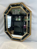 Front view showing octagonal shape, gold frame, bevelled border