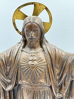 Front view of bronze-tone spelter statue of Jesus with halo and Sacred Heart emblem