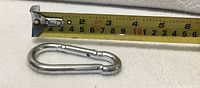 Close-up of one snap hook carabiner beside tape measure showing 3.5-inch length