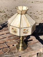 Full view of brass lamp with stained glass shade on pallet