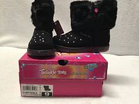 Boots displayed on original box showing front and side views, tags attached