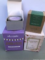 Group shot of four boxed candles showing brands and packaging