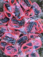 Pile of individually wrapped red jump ropes showing red cords and black handles