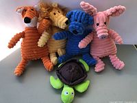 Group of five corduroy plush animal dog toys displayed upright