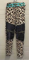 Front view of cheetah print leggings showing faux leather panels and zip pockets