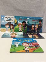 Front covers of six children’s books laid out upright and flat