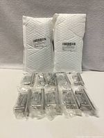 Two sealed 10-pack bubble envelopes and individually wrapped pulls with screws visible