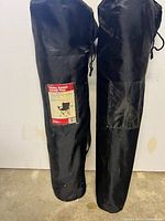 Two black carry bags containing folding armchairs